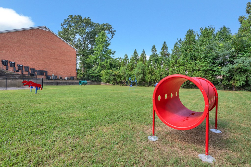 a swing set in a park next to a brick building